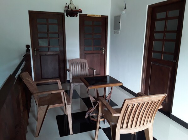 A dining area with a checkered floor, wooden furniture, and two doors with glass panels.