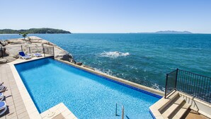 A clear blue pool with a view of the sea and distant mountains. - 1 Bright Point Apartment 5102 (Nelly Bay)