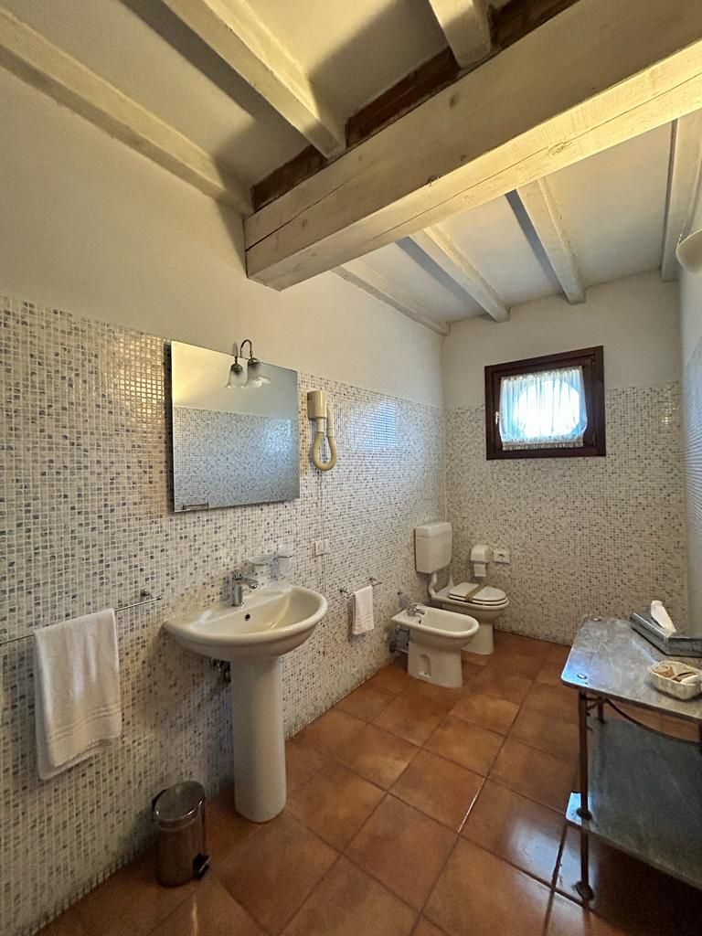 Ein Badezimmer mit Waschbecken, Spiegel, Toilette und Bidet.