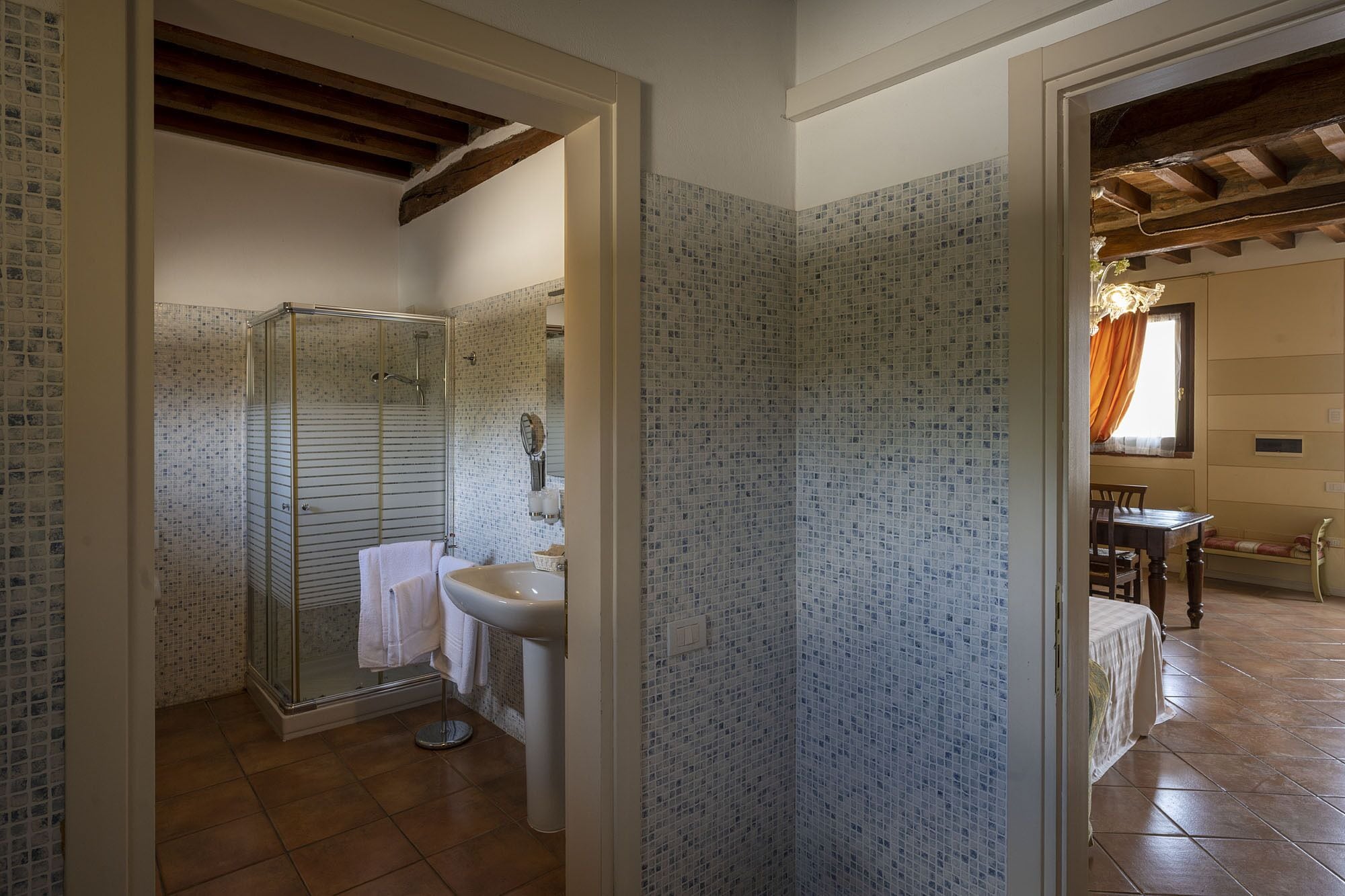 Une salle de bain avec une douche en verre, un lavabo et un mur carrelé.