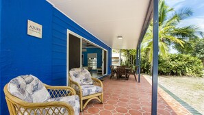 A covered outdoor area with wicker furniture and a tiled floor. - Azure on Geoffrey Bay (Arcadia)