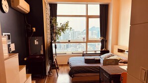 A modern hotel room with a large window, a bed, a desk, and a chair. - Travel House (Seoul)