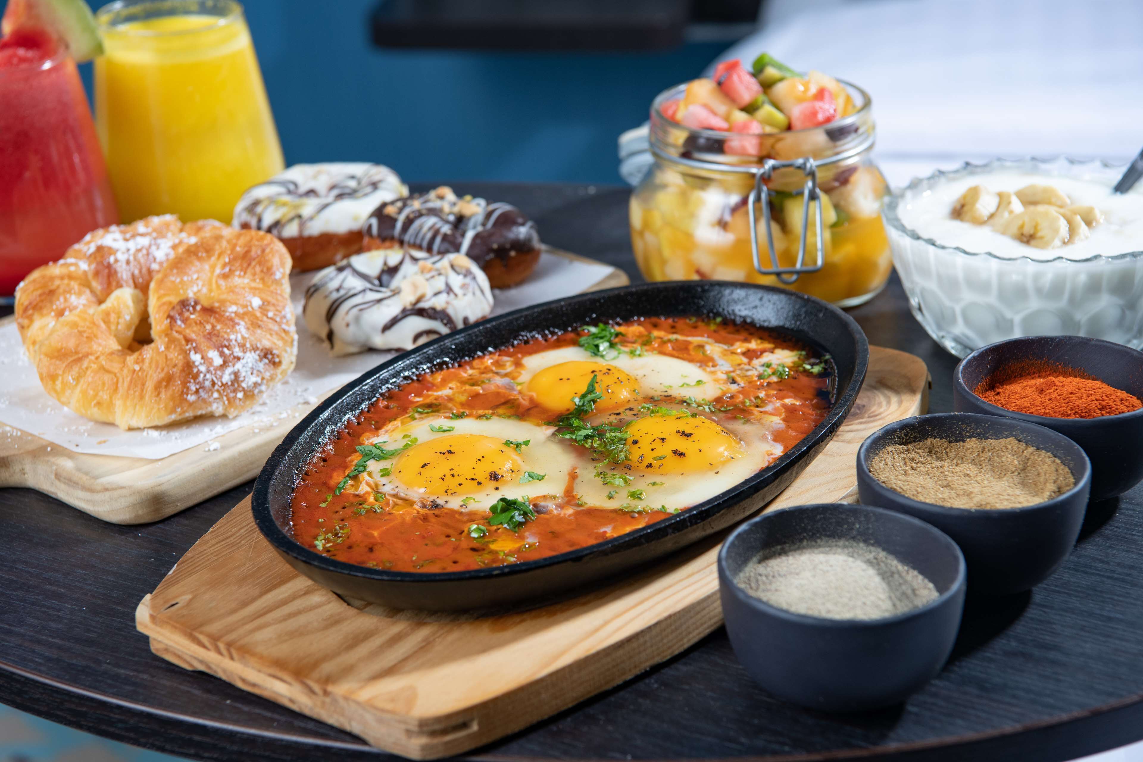 Una colazione con uova, pasticcini e condimenti.