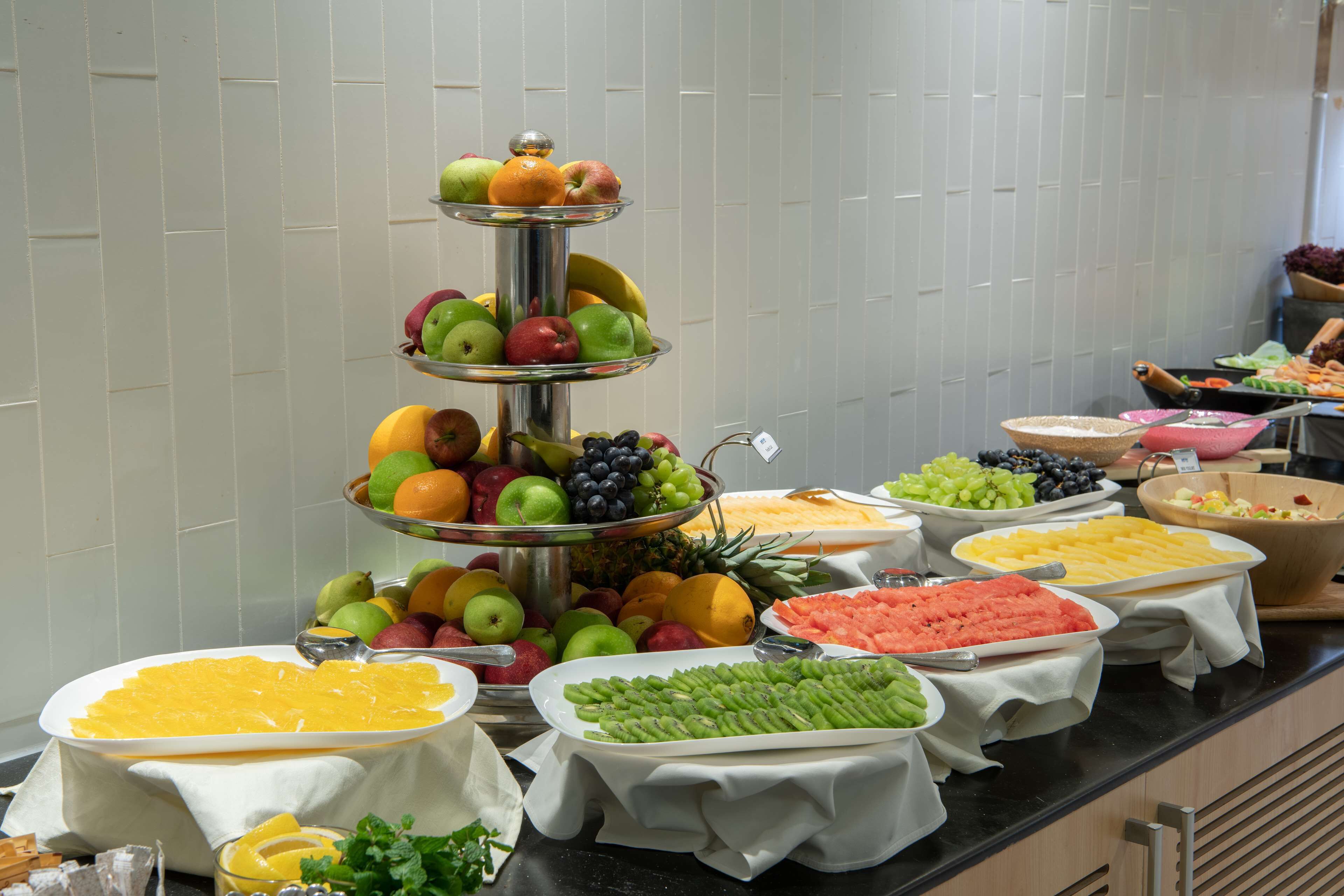 Un bufé con diversas frutas y verduras dispuestas sobre una barra.