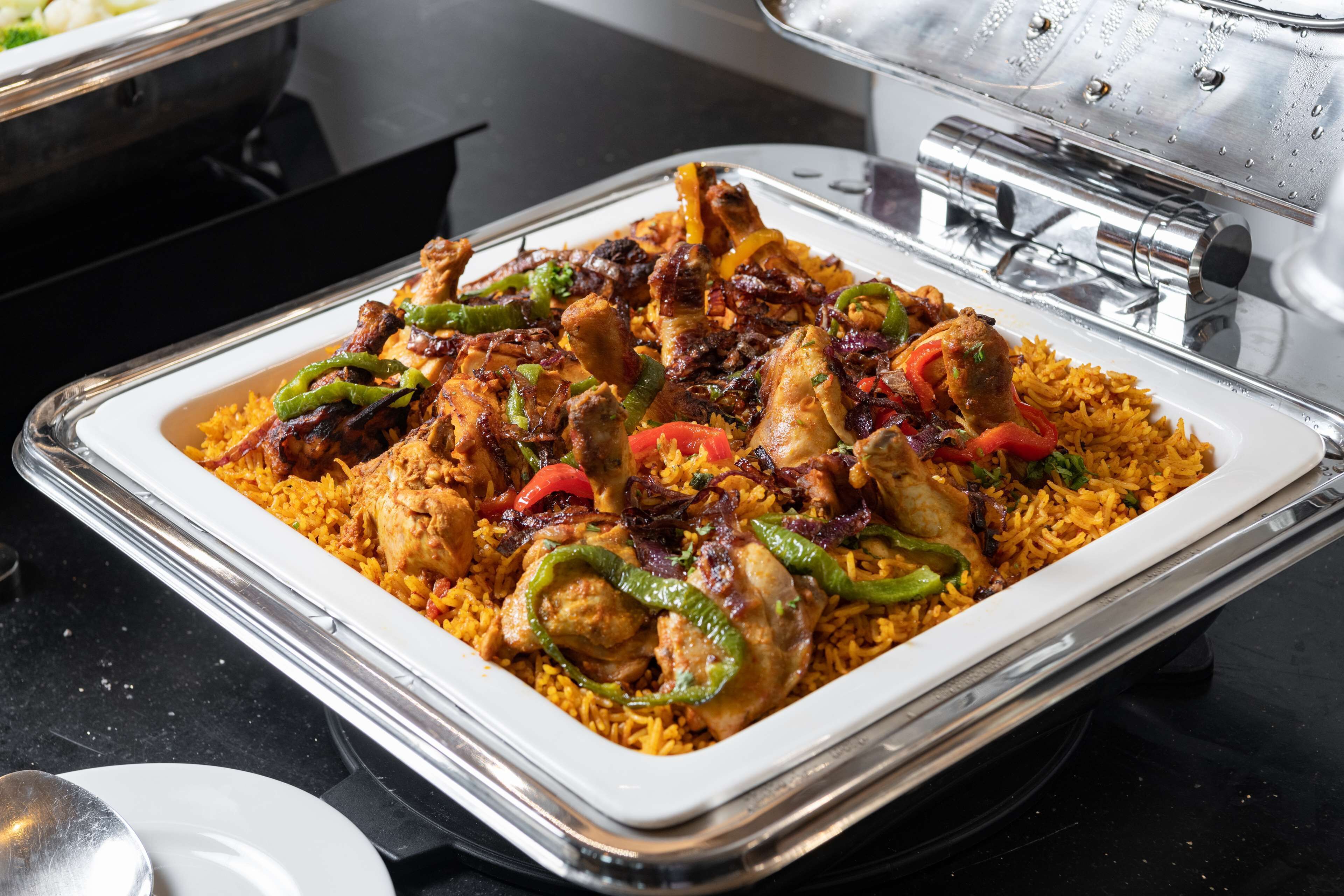 Un bufé con una variedad de platos, incluyendo arroz, pollo y verduras.
