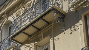 Een gebouw met sierlijke balkonnetjes van gesmeed ijzer en klassieke architectonische details.