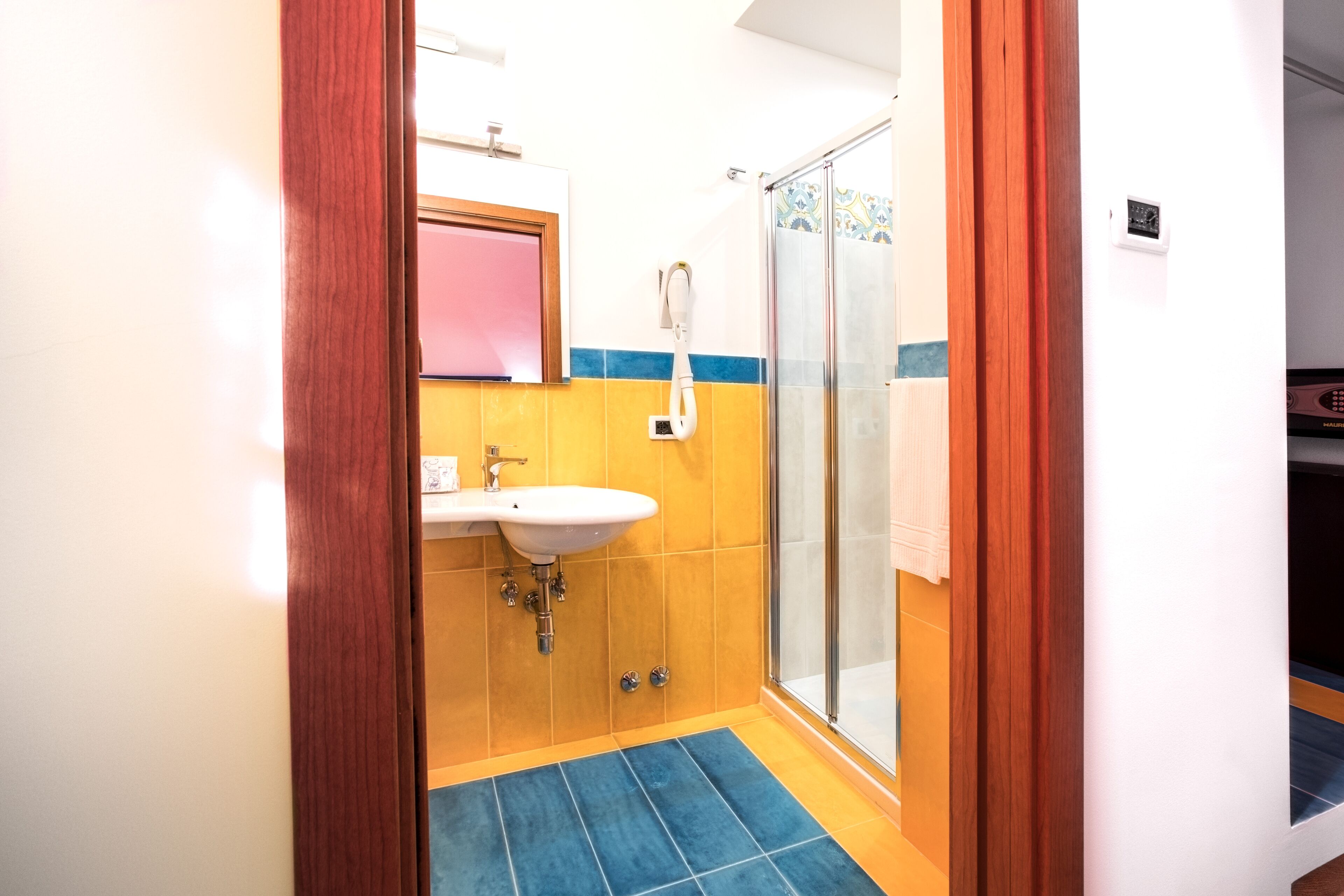 A bathroom with a sink, mirror, and shower.