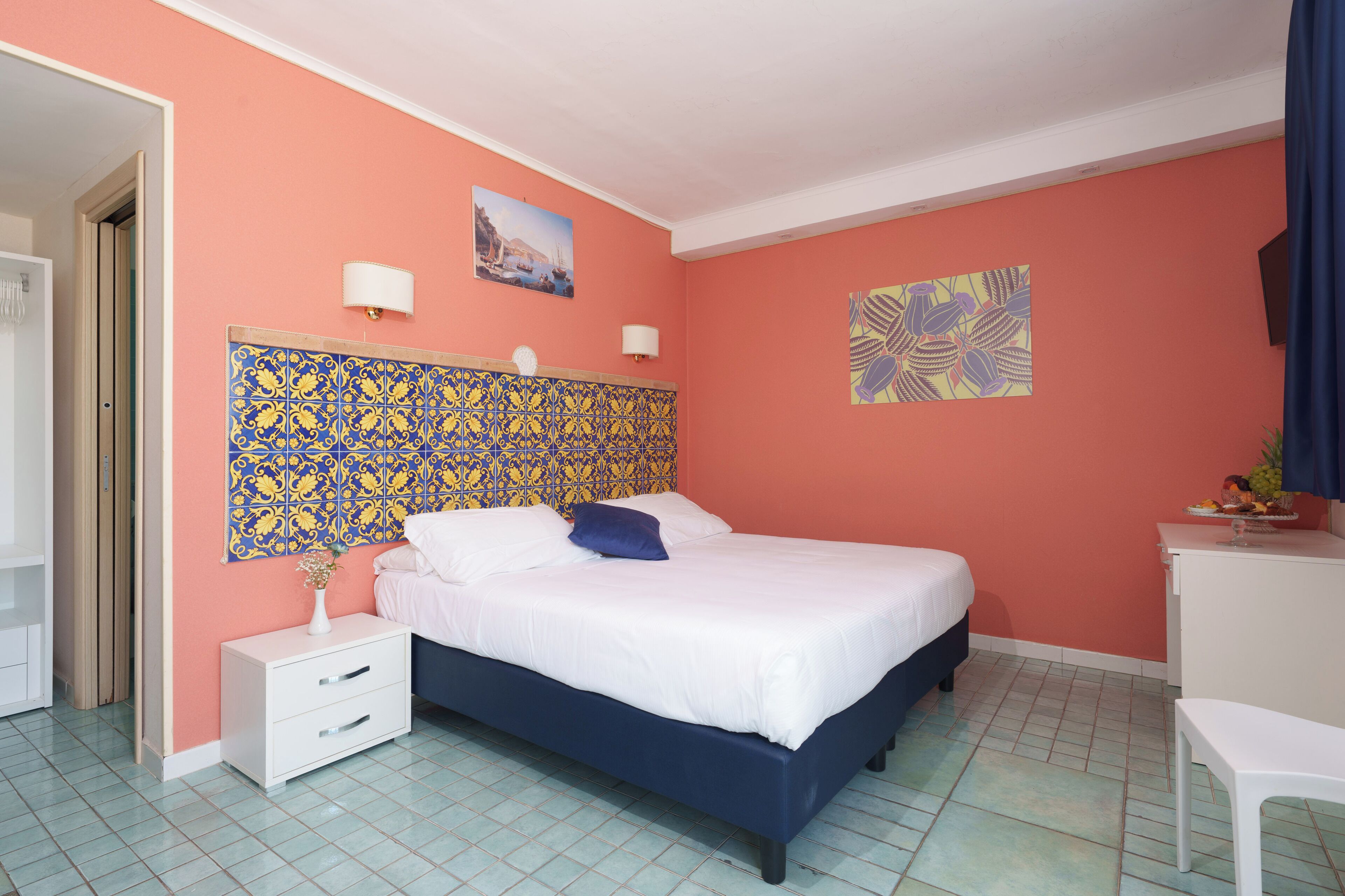 Un dormitorio con cama, mesita de noche, escritorio y silla.