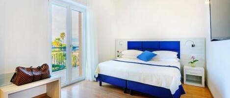 Un dormitorio con cama, una banca, una mesita de noche y vistas al exterior.