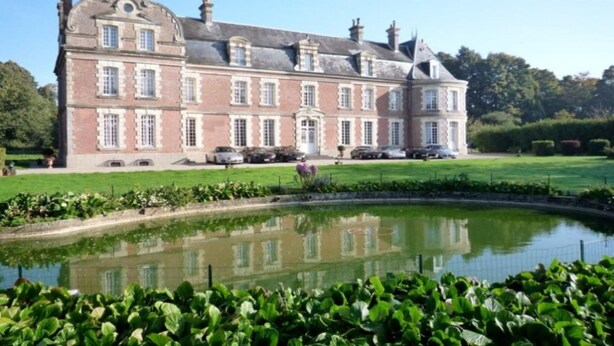 A large, historic building with a symmetrical facade, a central entrance, and a surrounding garden with a pond. - Château de Béhen (Behen)