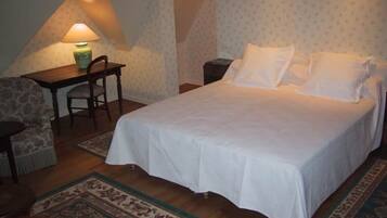 Une chambre à coucher avec un lit, un bureau, une chaise et une lampe.