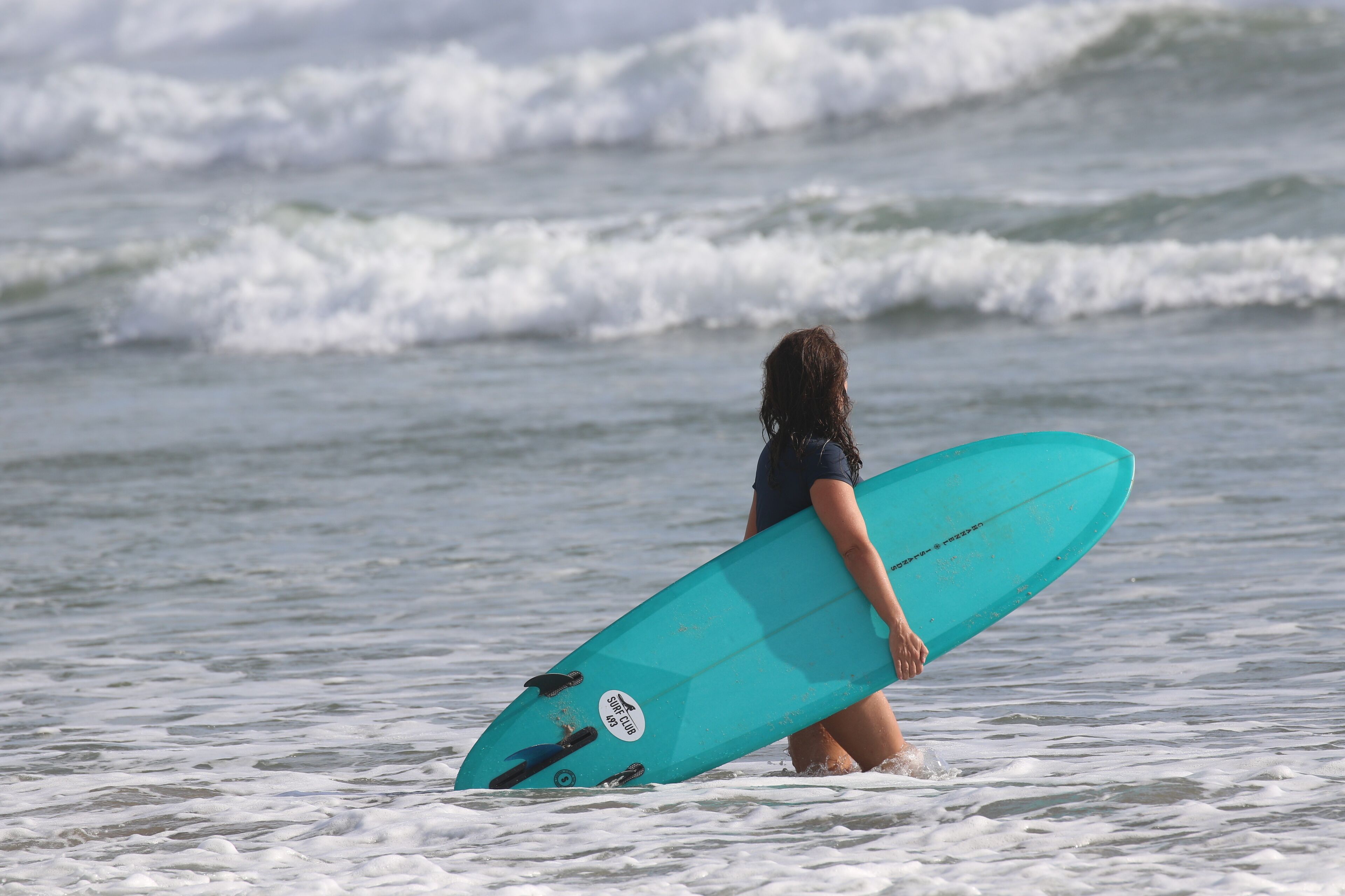 A person holding a surfboard in the ocean.