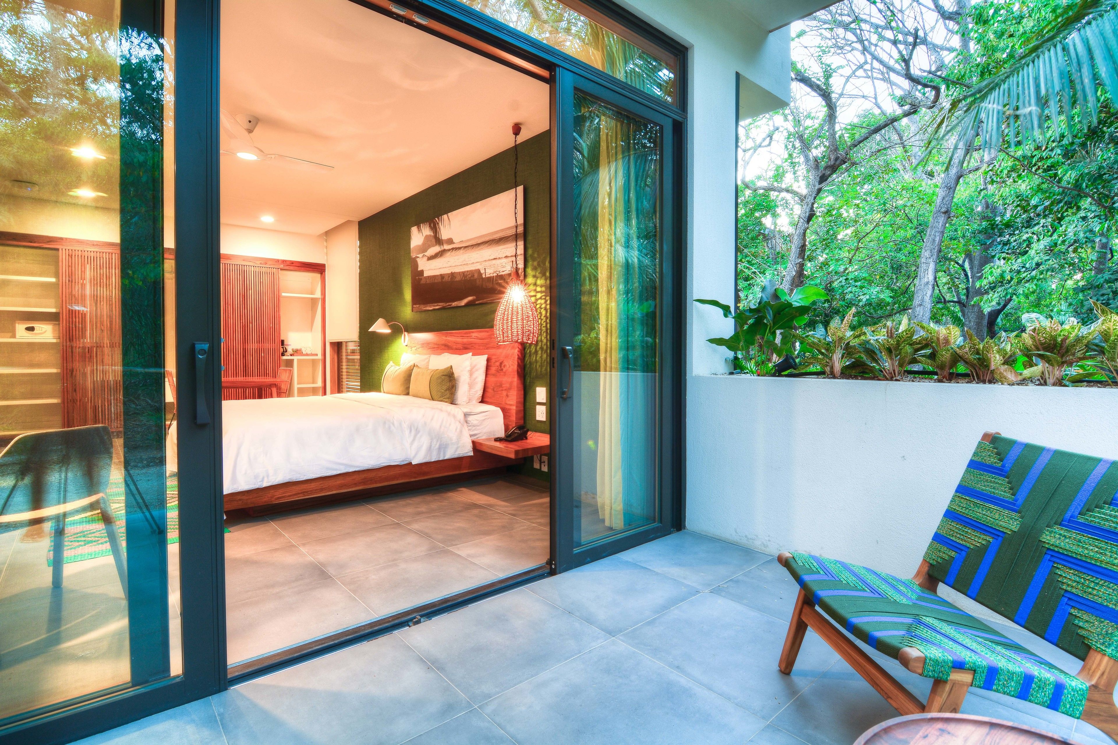 A bedroom with a bed, a nightstand, and a window.