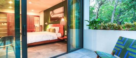 A bedroom with a bed, a nightstand, and a window.