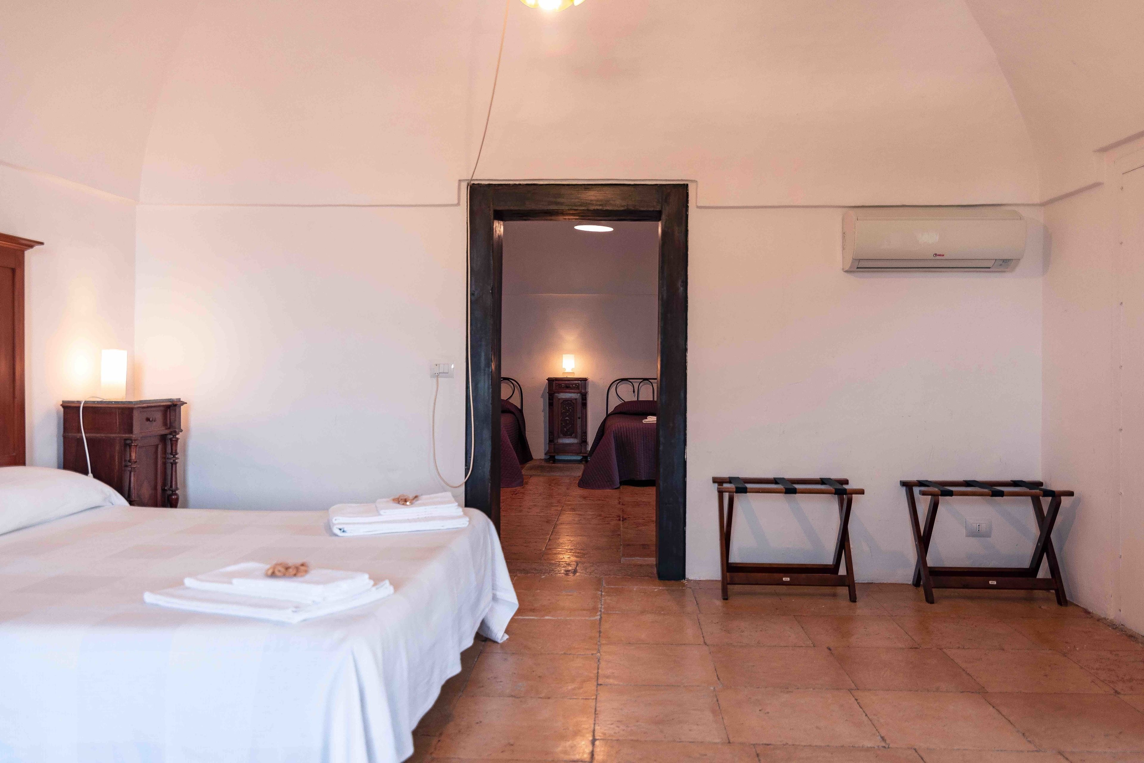 Habitación de hotel con cama, mesitas de noche, armario y aire acondicionado.