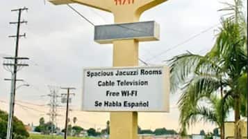 Placa do La Mirage Inn Suites & Spa, listando comodidades como quartos espaçosos com hidromassagem, televisão a cabo, Wi-Fi gratuito e equipe que fala espanhol.