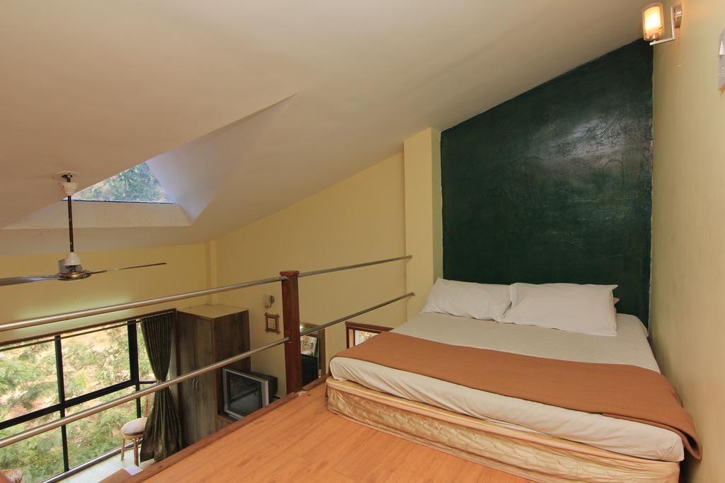 Un dormitorio con cama, vistas a través de un balcón y ventilador de techo.