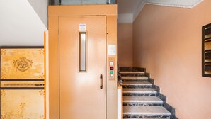 A staircase with a metal handrail and a door with a control panel. - Guest House Maison 6 (Rome)