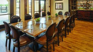 Un salón de conferencias con una larga mesa de madera, sillas de cuero y un candelabro.