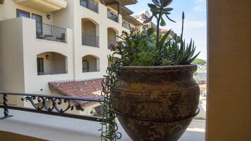 Una planta grande en maceta sobre la barandilla de un balcón.