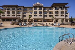 A hotel with a swimming pool, multiple balconies, and outdoor seating areas. - The Murieta Inn & Spa (Sloughhouse)