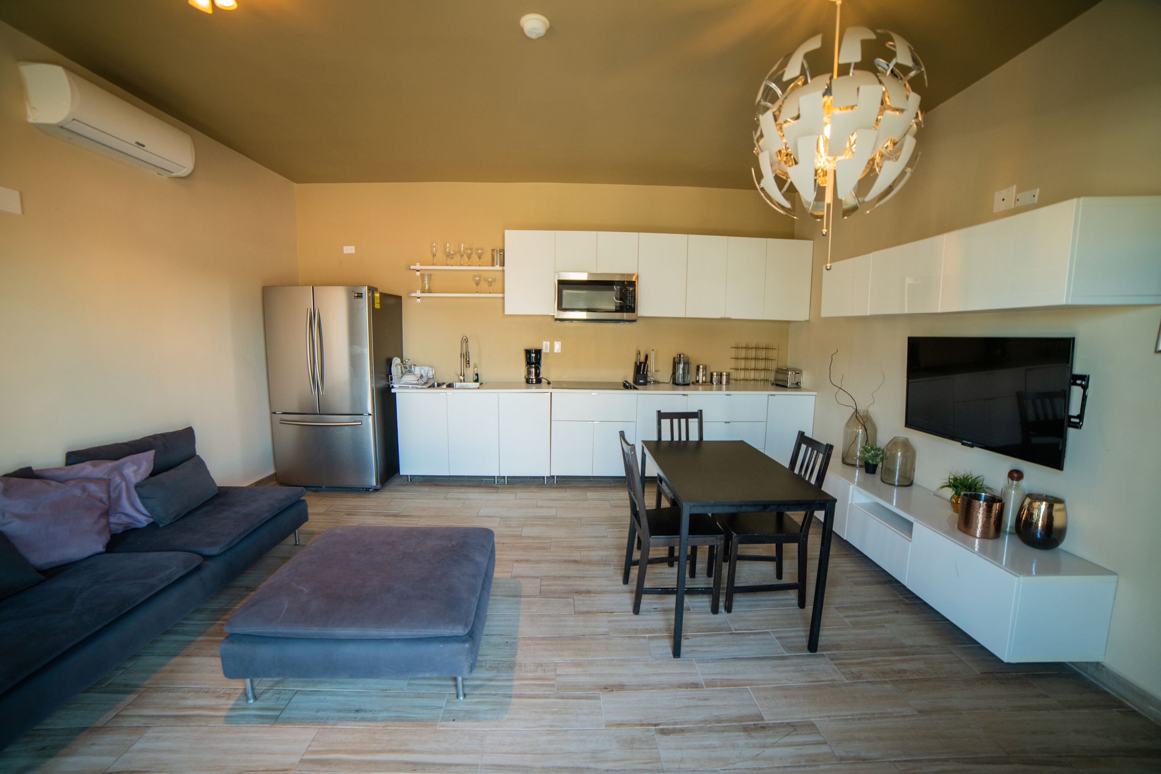 Una cocina moderna con microondas, refrigerador y comedor.