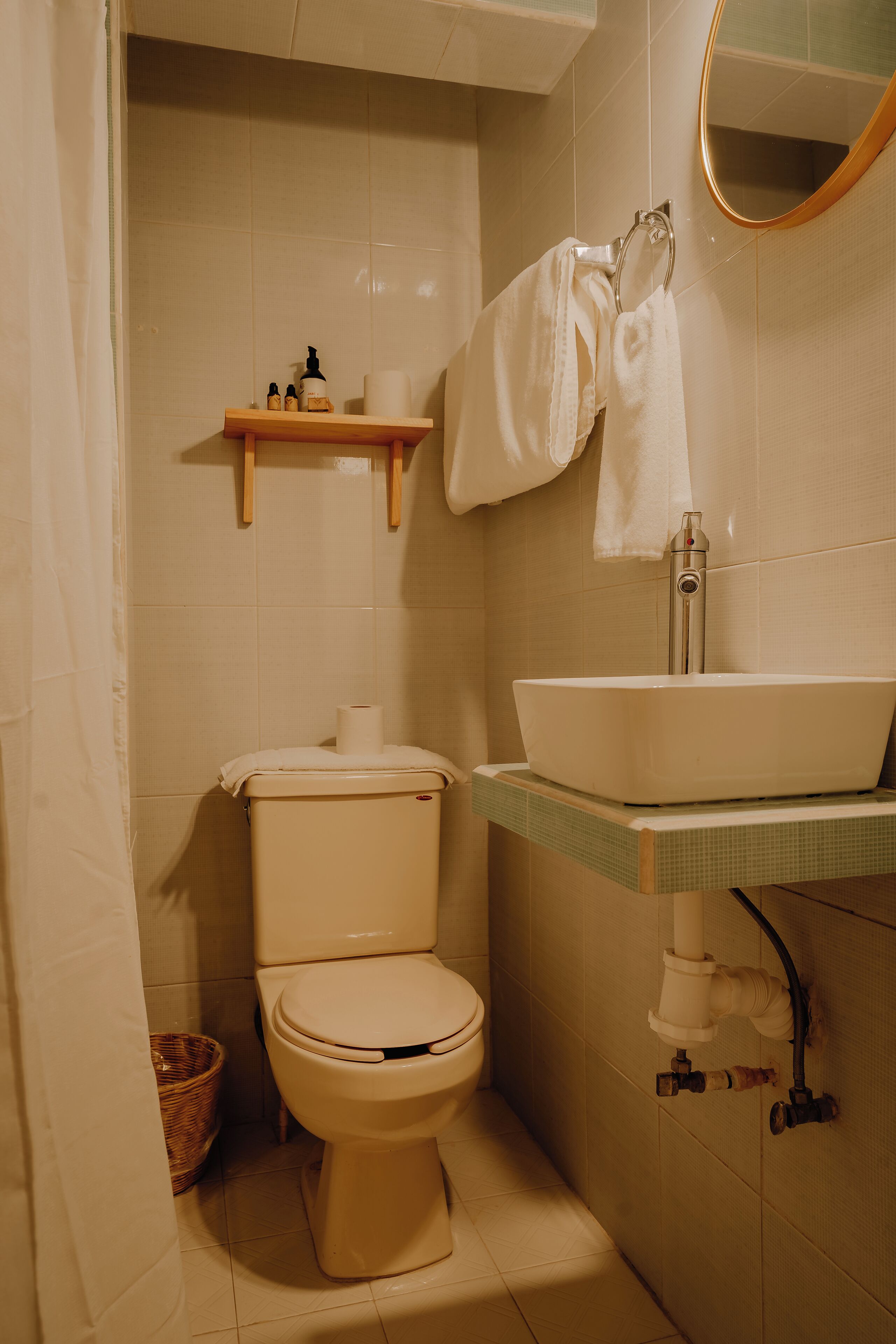 Une salle de bain avec des toilettes, un lavabo et un miroir.