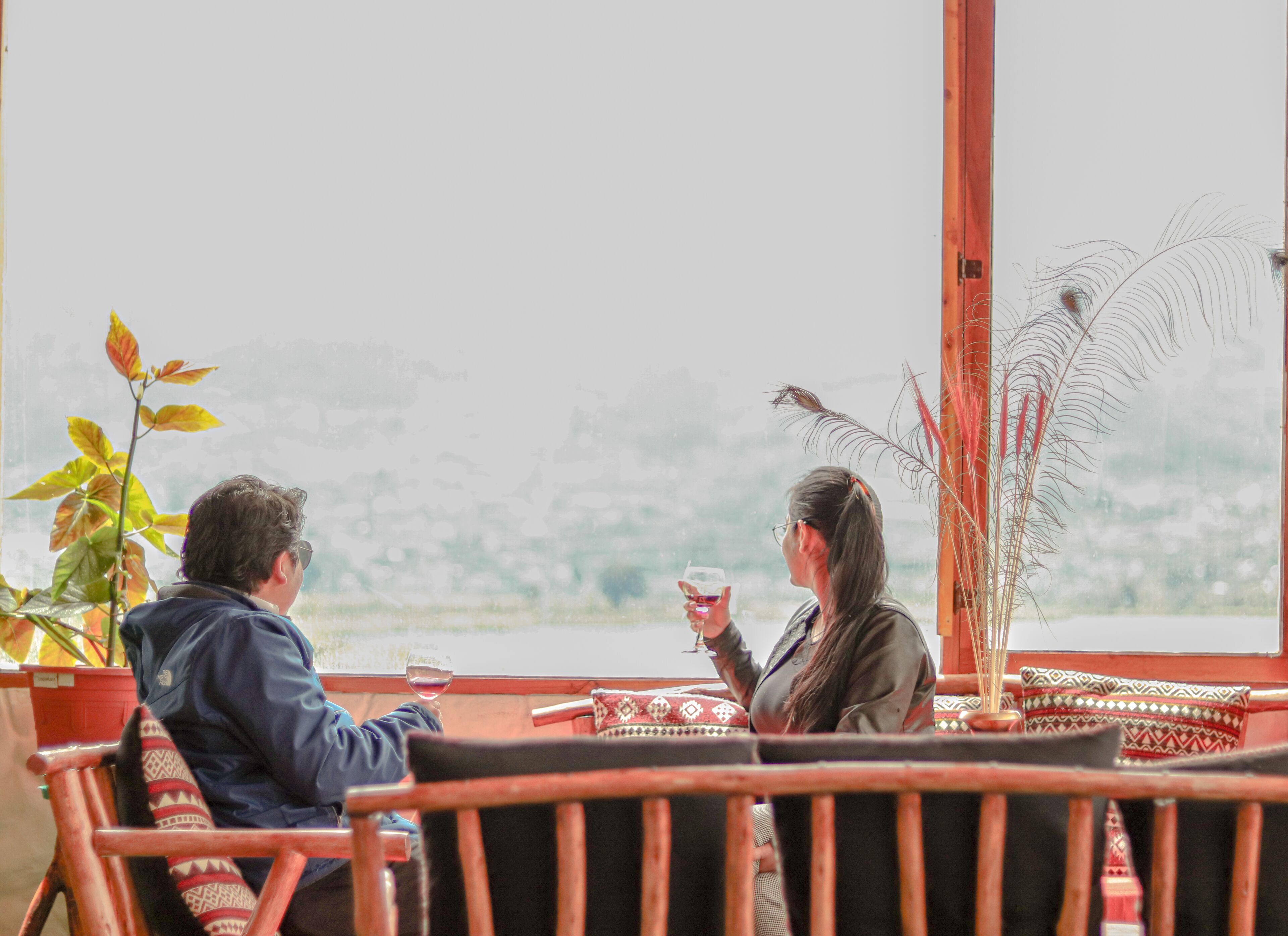 Dos personas sentadas en una mesa con vistas a un paisaje.
