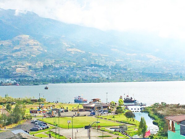 Vista al lago con estacionamiento, un parque pequeño y un muelle para barcos.