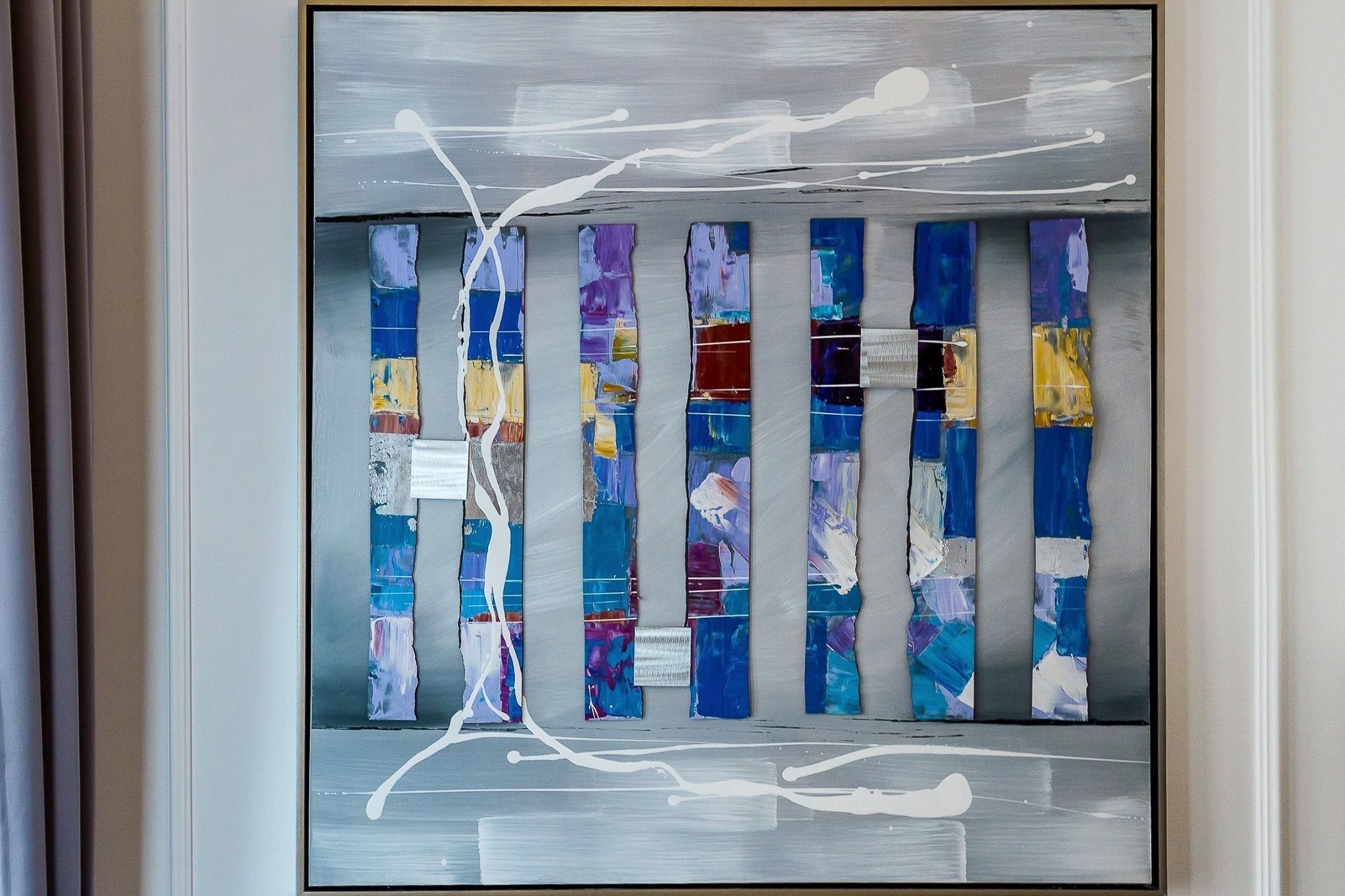 Una pintura abstracta enmarco, con paneles verticales de distintos colores y texturas.