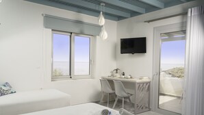 A modern hotel room with a bed, a desk with two chairs, a flat-screen TV, and a balcony with a view. - Paradisos (Sfakia)