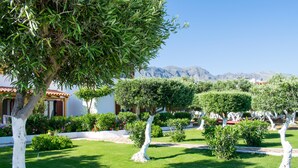 A well-maintained garden with neatly trimmed trees and a clear view of mountains in the background. - Paradisos (Sfakia)