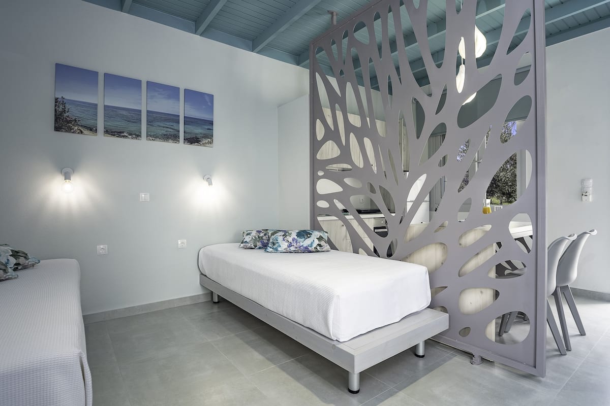 Une chambre moderne avec un lit, un élément de séparation décoratif et une vue sur la mer.