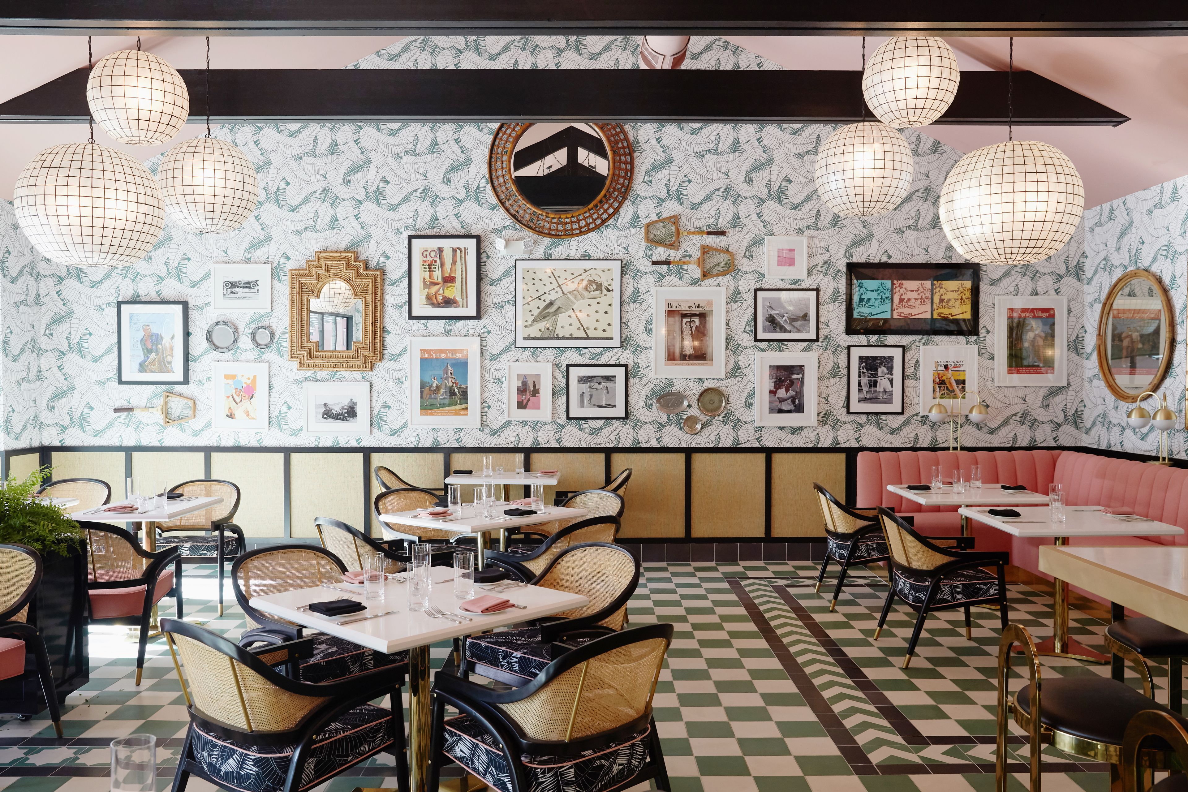 Interior de restaurante com chão xadrez, cadeiras de vime e mesas preparadas para refeições.