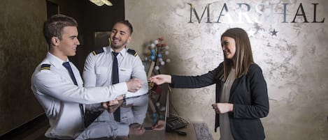 Mostrador de recepción de hotel con una pared de mármol y un letrero que dice "HOTEL MARSHAL".