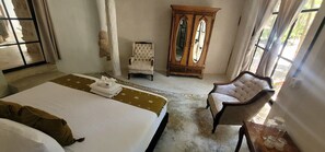 Une chambre d’hôtel avec un lit, une chaise, une armoire et une fenêtre.