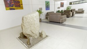 A modern lobby with a large rock sculpture, contemporary furniture, and abstract art on the walls. - Golden Sunrise Machupicchu (Machu Picchu)