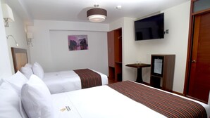 A hotel room with two beds, a television, a small table with glasses, and a painting on the wall. - Golden Sunrise Machupicchu (Machu Picchu)