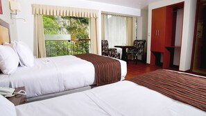 Een hotelkamer met twee bedden, een bureau, een stoel en een kledingkast.