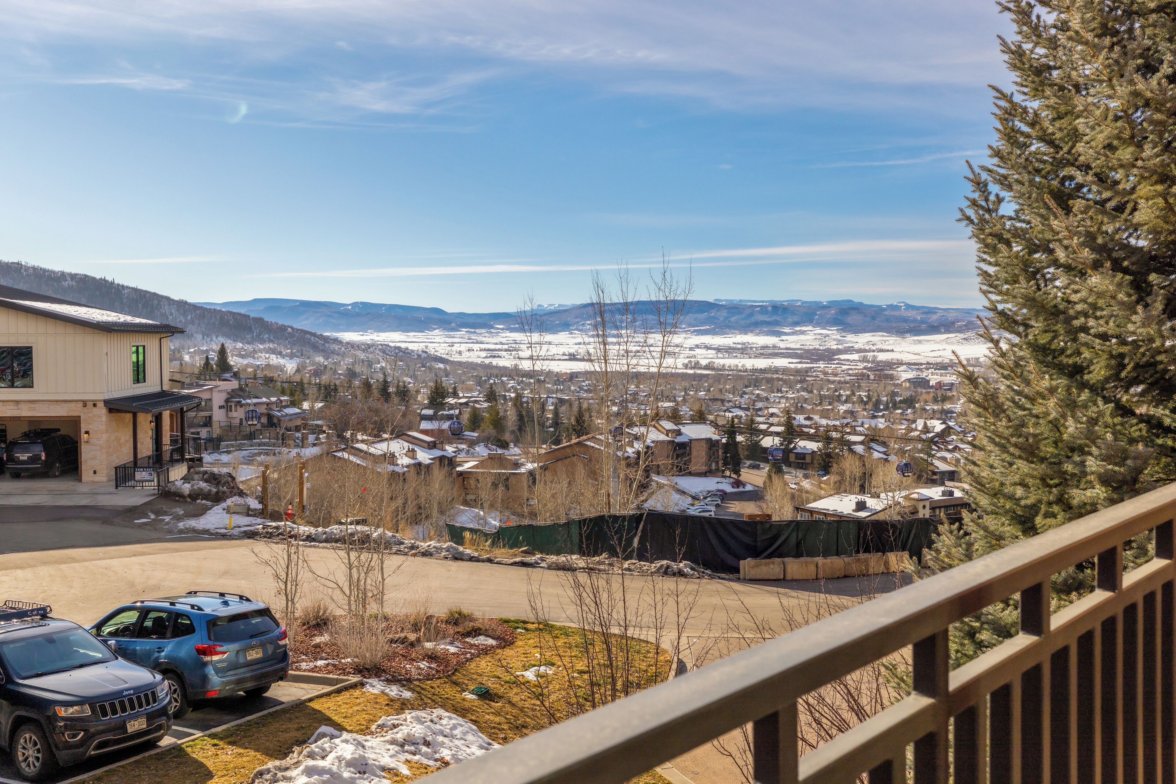 Un quartiere residenziale con case, un parcheggio e vista sulle montagne lontane.