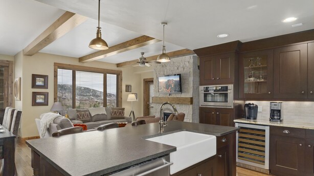 A modern kitchen with a large island, built-in appliances, and a stone accent wall. - Edgemont 2402 Luxury On Mountain Condo With Ski-In/Ski-Out Access! (Steamboat Springs)