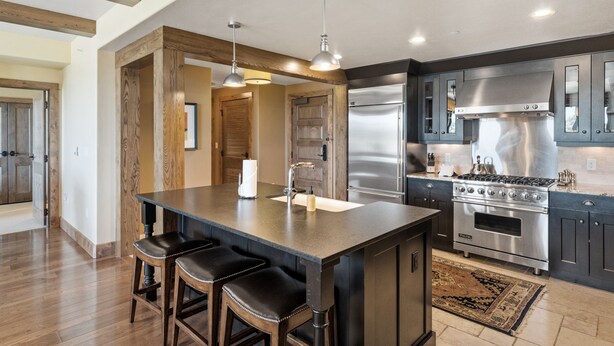 A modern kitchen with a central island, stainless steel appliances, and wooden accents. - Edgemont 2703 Luxury On Mountain Condo With Ski-In/Ski-Out Access! (Steamboat Springs)