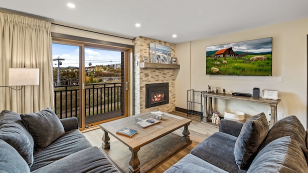 A living room with a fireplace, a sofa, a coffee table, and a TV.