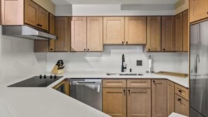 Una cocina moderna con armarios de madera, estufa de acero inoxidable y lavavajillas.