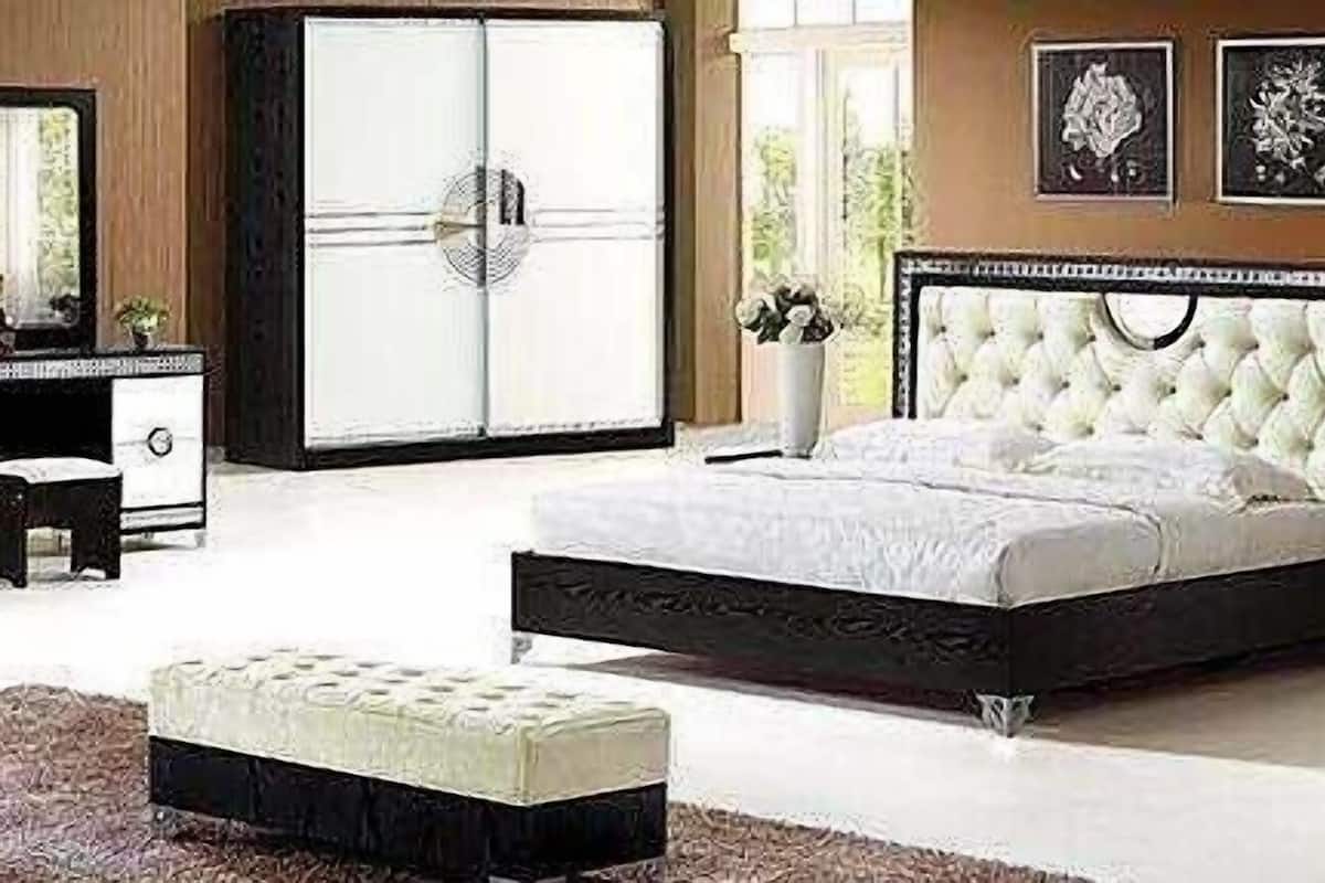 Ein Schlafzimmer mit einem großen Bett, einem Schminktischchen, einem Kleiderschrank und einer Kommode.