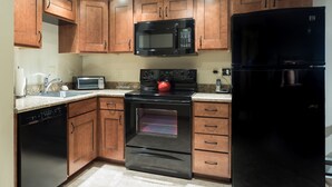 A kitchen with wooden cabinets, a black refrigerator, a microwave, a stove, and a dishwasher. - Bear Claw 100 On Mountain Studio With Ski-In/Ski-Out Access! (Steamboat Springs)