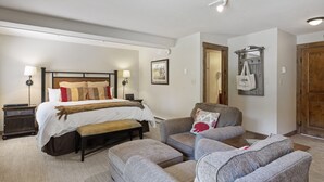 A bedroom with a large bed, two bedside tables, a bench, a sofa, and a wardrobe. - Bear Claw 100 On Mountain Studio With Ski-In/Ski-Out Access! (Steamboat Springs)