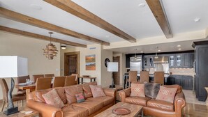 A spacious living area with leather sofas, a dining table, and a kitchen in the background. - Edgemont 2600 Luxury On Mountain Condo With Ski-In/Ski-Out Access! (Steamboat Springs)