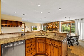 A kitchen with granite countertops, wooden cabinets, a stainless steel sink, and a built-in dishwasher. - Bear Claw 409 Premium On Mountain Condo With Ski-In/Ski-Out Access! (Steamboat Springs)