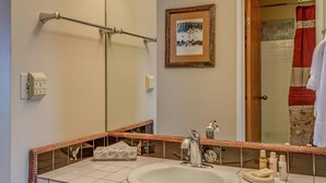 Une salle de bain avec un double lavabo, des meubles en bois, un grand miroir et un porte-serviettes.